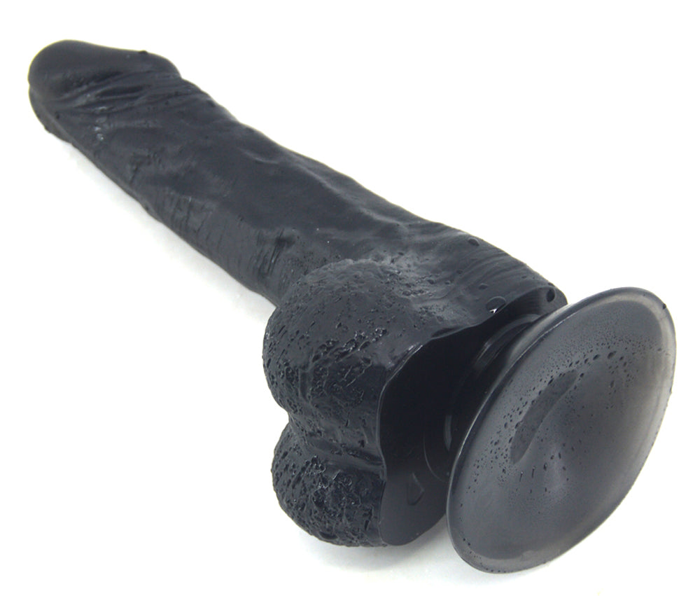 FAAK Essential Dildo in black, laying flat with suction cup and balls