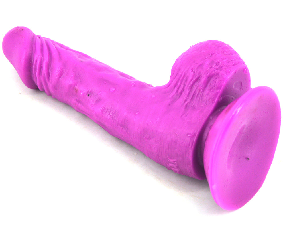 FAAK Essential Dildo in purple, laying on right showing suction cup
