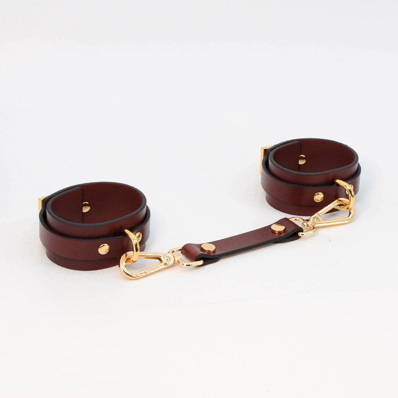 Close-up of maroon leather cuffs from the 8-piece bondage set by Come Now
